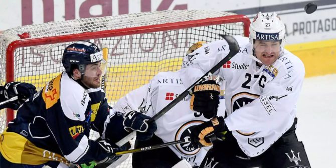 Die Spieler von Lugano und Ambri kämpfen um die Scheibe.