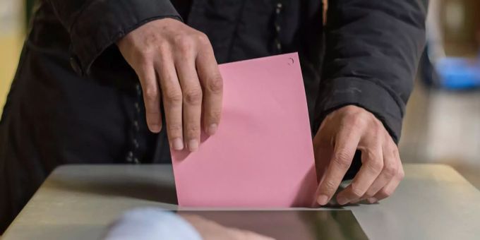 Ein Mann wirft seinen Stimmzettel in die Wahlurne. Kommunalwahl