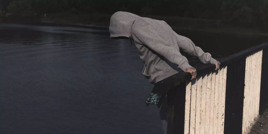 Ein Mann steht auf einer Brücke.