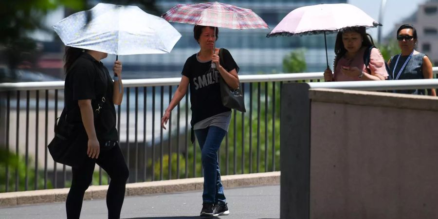 In Australien schützen sich Fussgänger vor der Sonne.