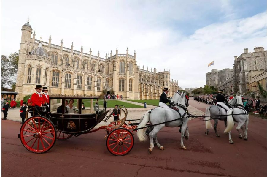 Jack Brooksbank und seine Frau Prinzessin Eugenie sitzen in einer Kutsche nach ihrer Hochzeit in der St.-Georges-Kapelle von Schloss Windsor.