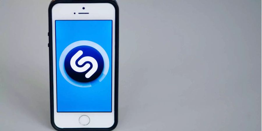 Das Logo vom Musik-Identifikationsdienst «Shazam» wird auf dem Display von einem Apple iPhone 5s angezeigt.