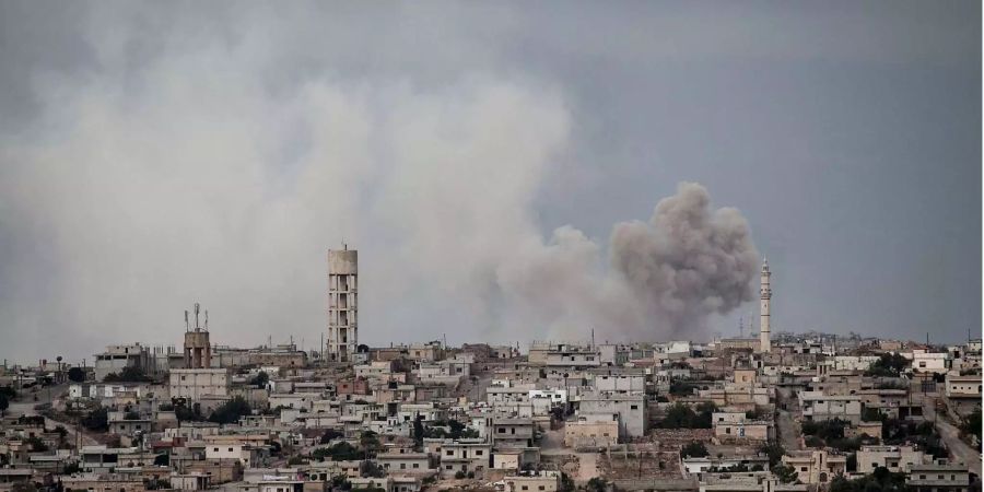 Rauch steigt nach einem Bombenanschlag auf ein Rebellenversteck von einem Dorf nahe Kafr Nabuda in der syrischen Provinz Idlib auf.