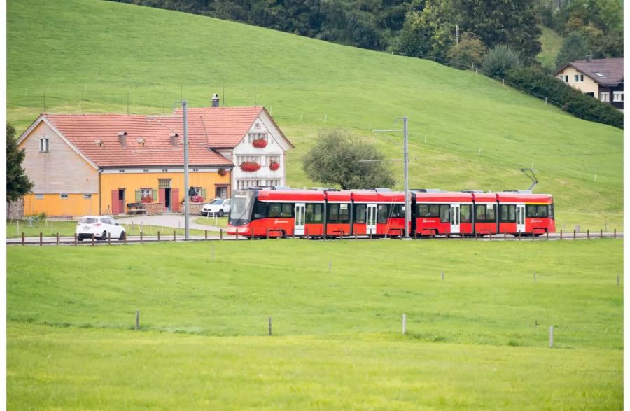 Rote Appenzeller Bahn auf ihrem Weg mit einem Haus daneben und Weiden - zvg Appenzeller Bahnen