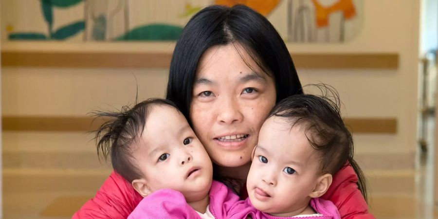 Die vierzehn Monate alten Nima (r) und Dawa (l) sitzen mit ihrer Mutter Bhumchu Zangmo im Royal Children's Hospital in Melbourne.