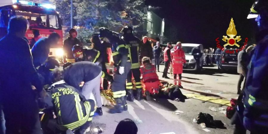 Rettungskräfte kümmern sich nach einer Massenpanik in einer Diskothek um Verletzte.