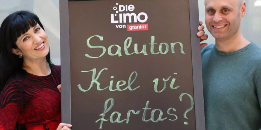 Mitglieder der Esperanto-Sprachgemeinschaft halten ein Schild mit der Aufschrift «Hallo, wie geht es dir» hoch.