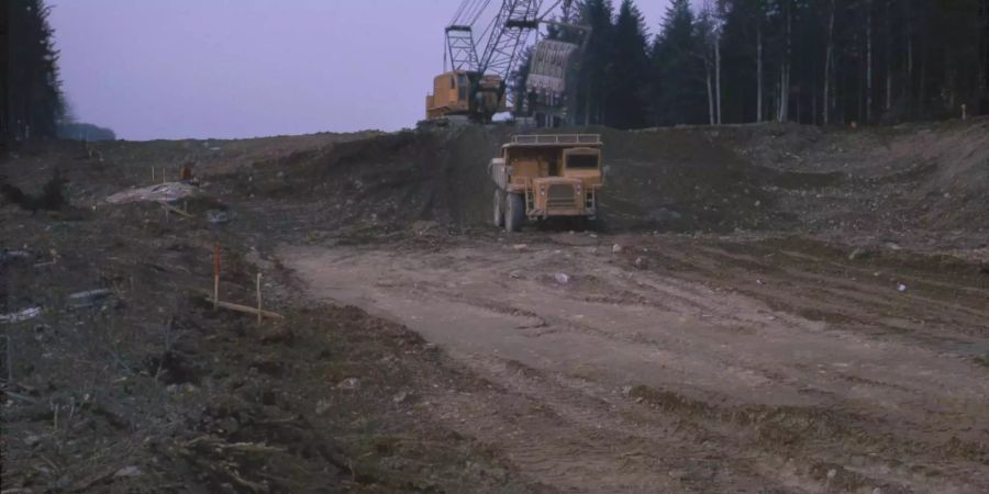 Bild aus den 70er-Jahren: Bauarbeiter essen beim Bau der Autobahn auf dem Findling Znüni (siehe links)