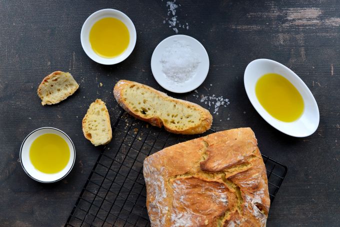 Beim Verkosten des Olivenöls mit Brot und Salz entwickeln sich in Mundhöhle, Rachen und Hals Schärfe und Bitternoten von dezent und flüchtig bis kräftig und lang anhaltend. Brot Olivenöl Schälchen Scheiben Salz