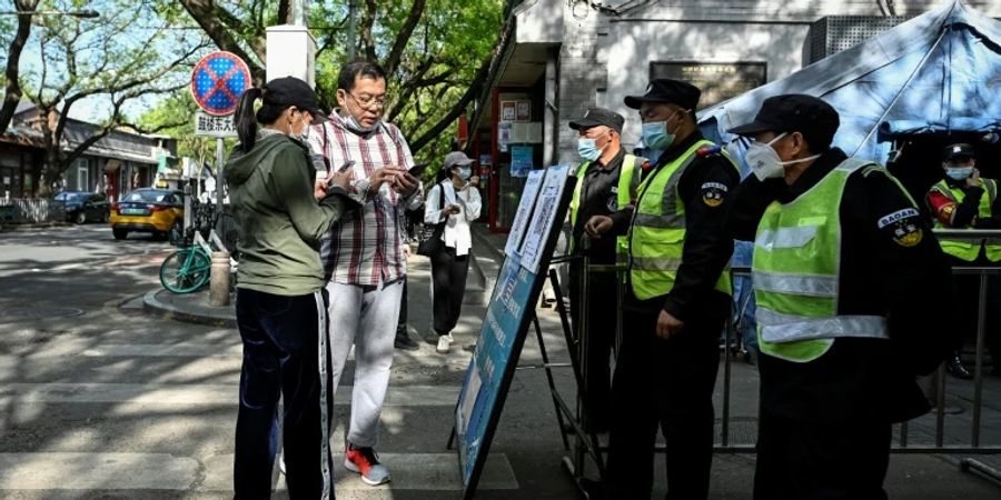 Menschen zeigen vor Bummel in Pekinger Geschäftsstrasse Negativtest