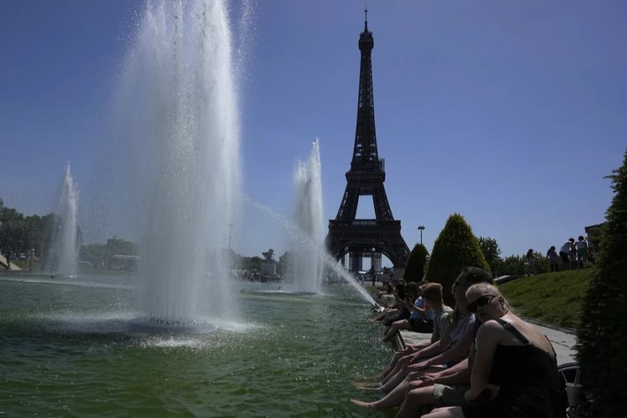 Es ist heiss: Menschen kühlen sich in Paris, Frankreich, in einem Brunnen ab.