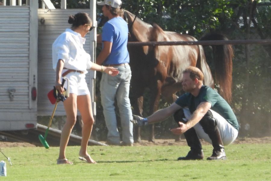 Meghan Markle trägt Prinz Harrys Polo-Ausrüstung, während er Aufwärmübungen macht.