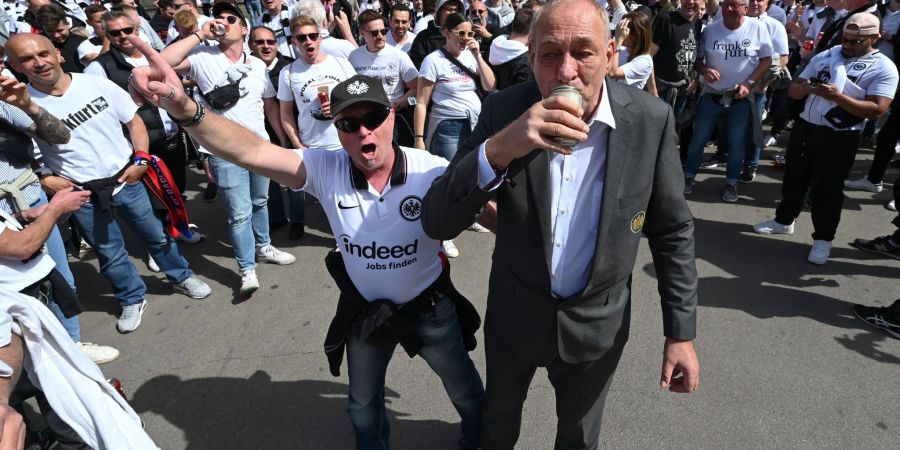 Eintracht-Präsident Peter Fischer (r) trinkt mit den angereisten Eintracht-Fans am Treffpunkt Placa de Catalunya ein Bier.