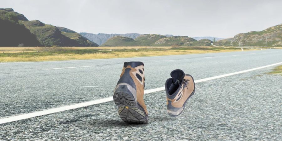 Wanderschuhe laufen allein durch Strasse Bergkulisse Animation