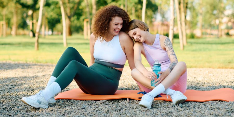 Frauen lachen und machen Yoga