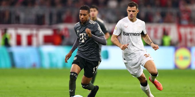 Michael Olise (L) von Bayern München im Duell mit Leverkusens Granit Xhaka. bayern münchen