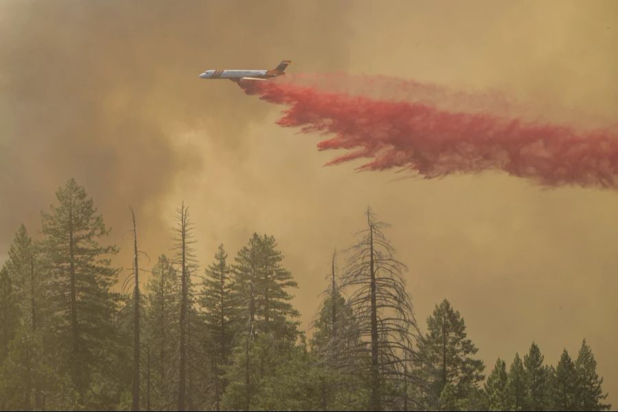 Ein Flugzeug wirft Löschmittel auf das Park Fire in der Nähe von Forest Ranch, Kalifornien, Sonntag, 28. Juli 2024.