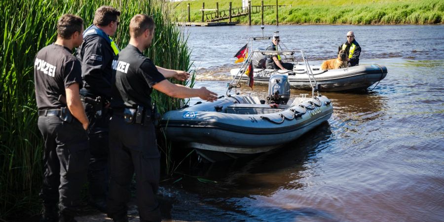 Einsatzkräfte der Polizei fahren bei der Suche nach dem vermissten Arian mit Spürhunden auf Schlauchbooten über die Oste.