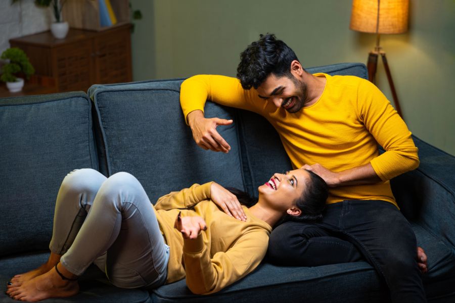 Mann und Frau lachend auf einem Sofa