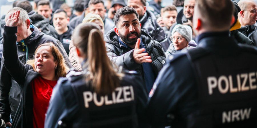 dpatopbilder - Aufgebrachte Kunden diskutieren vor der Sparkassenfiliale in Buer mit Polizeibeamten nach der Räumung des Vorraums der Filiale. Foto: Christoph Reichwein/dpa - ACHTUNG: ...