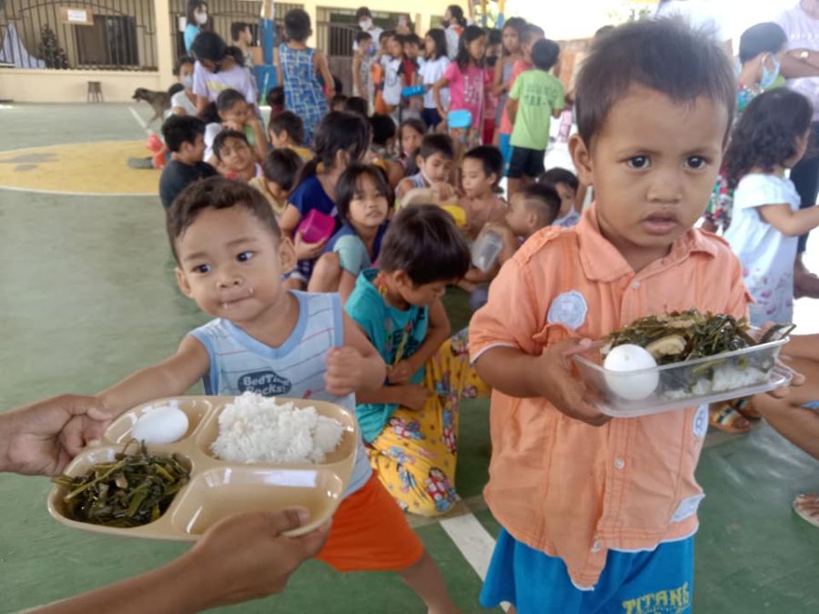 In einem ANC stehen Kinder Schlange fürs Essen.