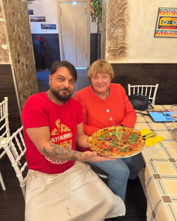 Die frühere Bundeskanzlerin und der Pizzaiolo posieren mit dem italienischen Gaumenschmaus. Angela Merkel