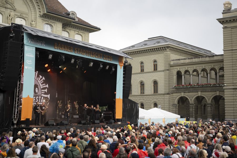 Besucherinnen und Besucher hören ein Konzert von Traktorkestar feat. Stephan Eicher auf dem Bundesplatz.