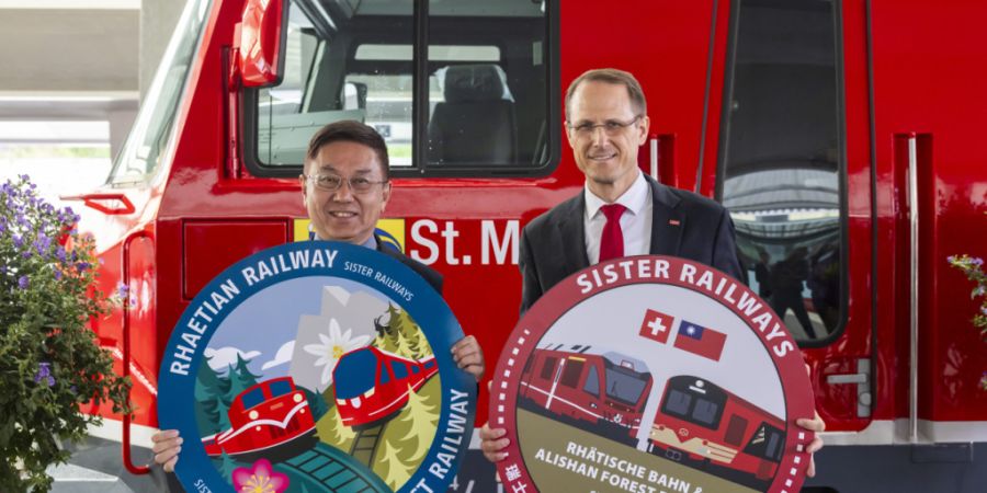 Hwa-Ching Lin von der taiwanesischen Alishan Forest Railway (links) und RhB-Direktor Renato Fasciati feiern das neue Abkommen der beiden Bahnen in St. Moritz mit einer Lokomotiventaufe.