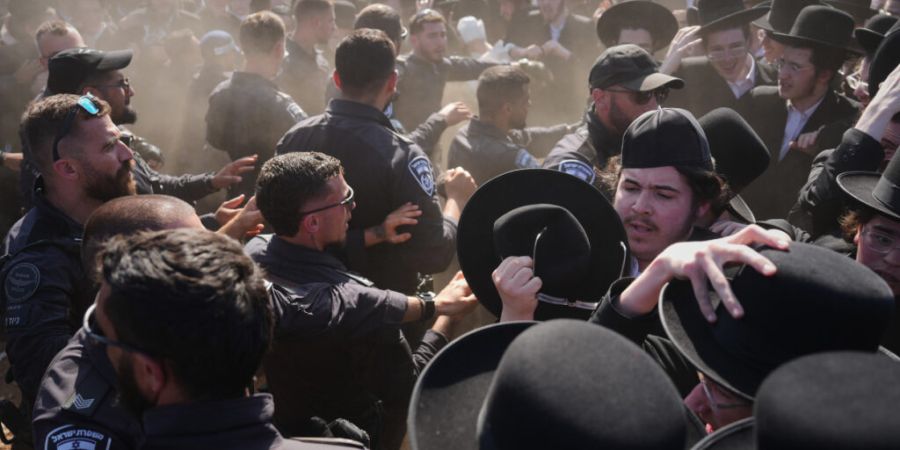 Ultraorthodoxe jüdische Männer geraten während einer Demonstration gegen die Wehrpflicht für alle vor einem Militärgefängnis in der Nähe von Kfar Yona, Israel, am Mittwoch mit de...