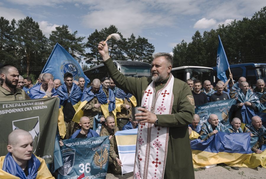 Ein Militärseelsorger segnet zurückgekehrte ukrainische Kriegsgefangene.