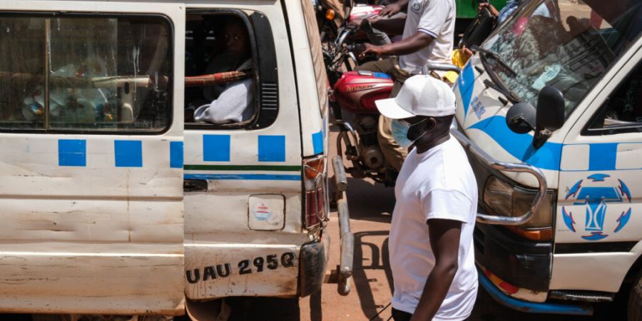 dpatopbilder - Ein Mann mit einer Schutzmaske geht eine belebte Straße in Kampala, Uganda, entlang. Foto: Hajarah Nalwadda/AP/dpa/Symbolbild