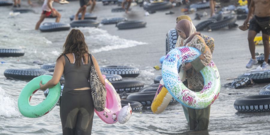 Migranten stehen im Wasser beim Versuch, die Grenze zwischen Ceuta und Marokko zu überqueren. Foto: Marcos Moreno/EUROPA PRESS/dpa