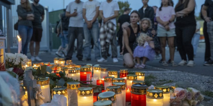 Teilnehmerinnen und Teilnehmer des Schweigemarschs halten vor der Aarauer Pferderennbahn für eine Schweigeminute inne.