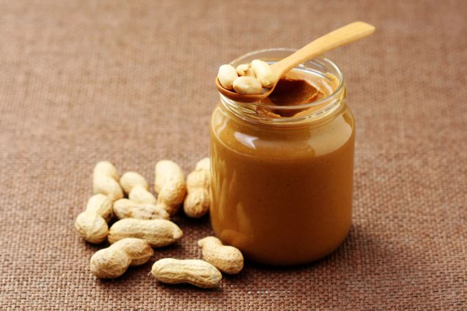 Massiere die Erdnussbutter sanft in den Kaugummi ein. erdnussbutter im glas