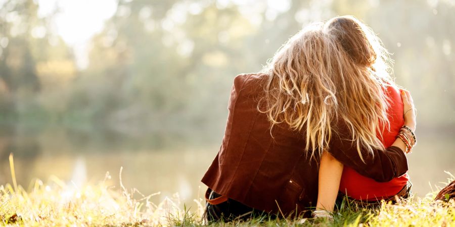 zwei frauen liegen sich in den armen, wiese, fluss, sonne, sommer