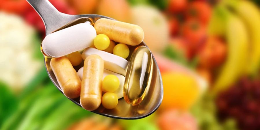 Löffel Mix Tabletten und Pillen Hintergrund Gemüse und Obst