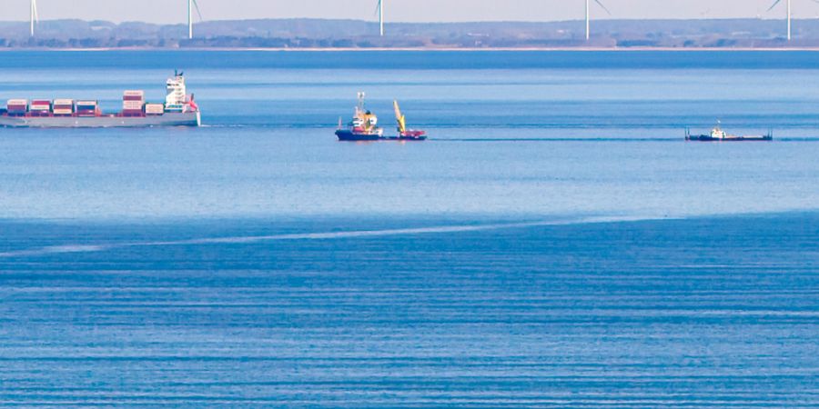 Das Schiff «Fortuna B» (M.) zieht am Mittag vor Fehmarn die Barge mit dem gestrandetem Wal (Luftaufnahme mit einer Drohne). Foto: Bodo Marks/dpa