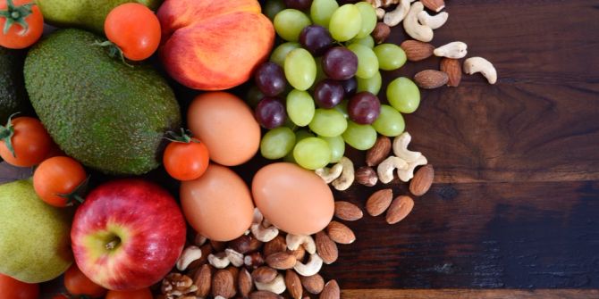 Lebensmittel Tisch Eier Nüsse Apfel Avocado Weintrauben Tomaten