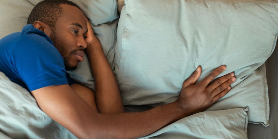 Nachdenklicher Mann im Bett