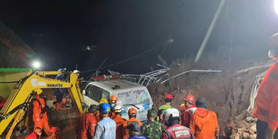 Retter suchen am Ort eines Erdrutsches im Dorf Cihanjuang nach Menschen. Foto: -/Indonesian National Disaster Mitigation Agency/AP/dpa