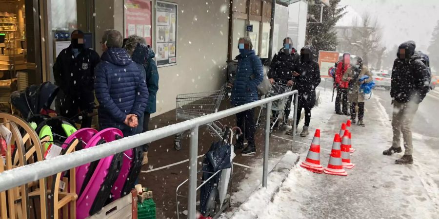 Die Kunden stehen vor dem Coop in Adelboden BE Schlange.