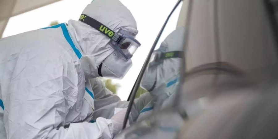 Ein Mitarbeiter der Corona-Abstrichstelle Heilbronn führt einen Coronatest durch. Foto: Sebastian Gollnow/dpa