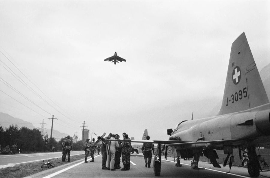 Auf einem abgesperrten Teil der Autobahn bei Walenstadt SG führt am 15. Oktober 1985 die Luftwaffe der Schweizer Armee eine Übung mit Kampflugzeugen durch. Ein F-5E Tiger II wird zum Start klargemacht, während ein Hawker Hunter bereits in der Luft ist.