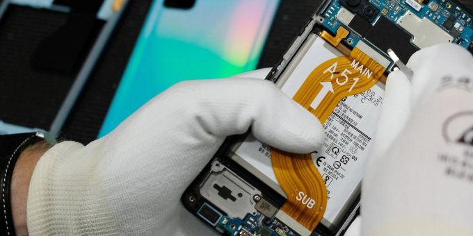 Ein Mobiltelefon wird in einer Werkstatt repariert. Ein Mobiltelefon wird in einer Werkstatt repariert.
