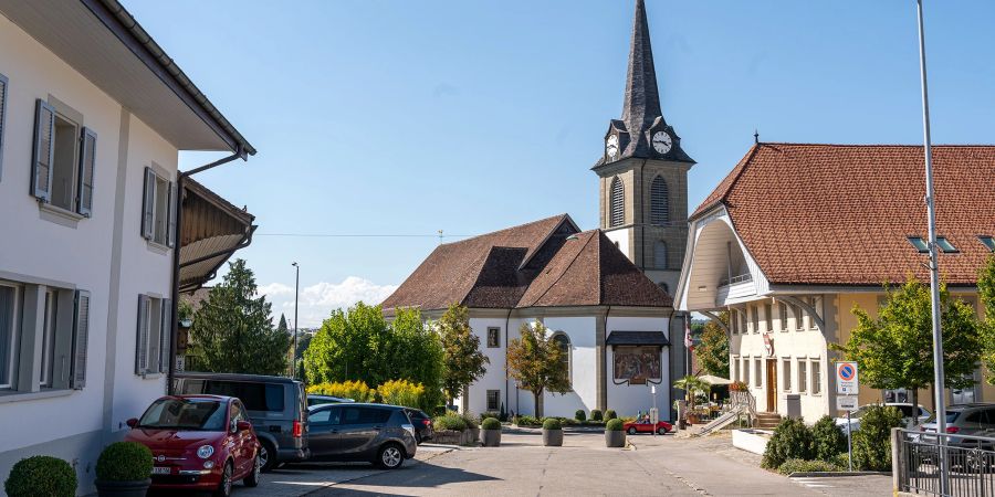 Die römisch-katholische Kirche von Düdingen von der Chännelmattstrasse aus gesehen. Rechts der Gasthof zum Ochsen.