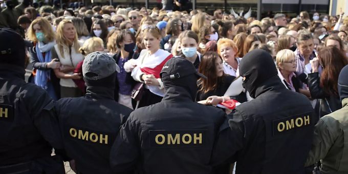 Polizisten der Spezialeinheit OMON stehen bei einem Protest gegen die Ergebnisse der belarussischen Präsidentenwahl vor den Demonstrantinnen. Belarus