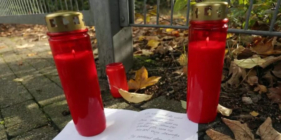Kerzen und ein Brief liegen vor dem Gelände in Duisburg, auf dem ein Mädchen tot aufgefunden wurde. Foto: David Young/dpa