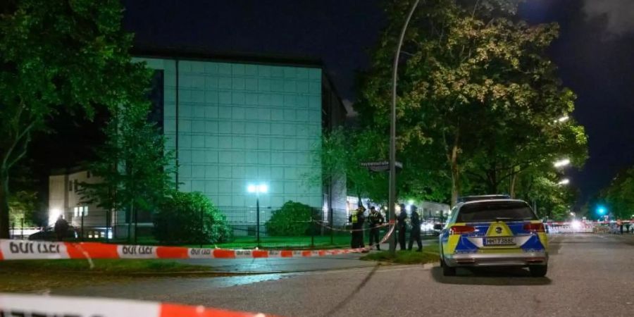 Polizisten stehen am abgesperrten Tatort vor der Synagoge. Foto: Jonas Walzberg/dpa