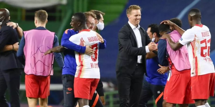 Die Spieler von Leipzig freuen sich nach dem Sieg mit dem Betreuerstab. Foto: Lluis Gene/Pool AFP/AP/dpa