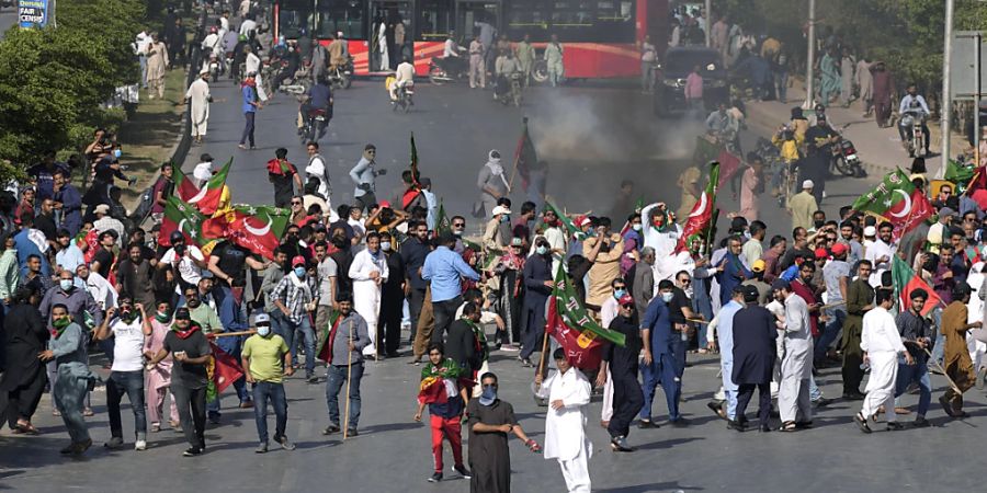 Anhänger des ehemaligen pakistanischen Premierministers Khan werfen Steine, um gegen seine Verhaftung zu protestieren. Der ehemalige pakistanische Premierminister Khan ist wegen Ermittlungen in einem Korruptionsverfahren verhaftet worden. Foto: Fareed Khan/AP/dpa